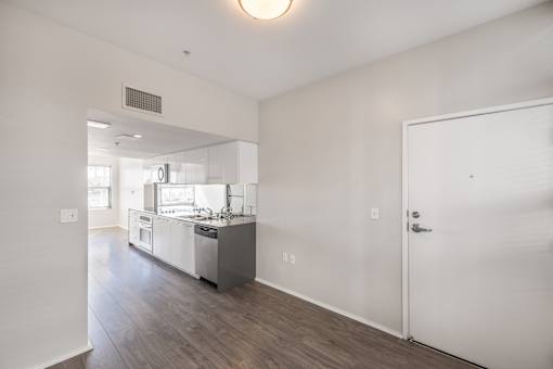 A kitchen with white cabinets and a white door.