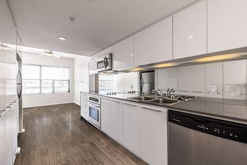 A modern kitchen with white cabinets and stainless steel appliances.