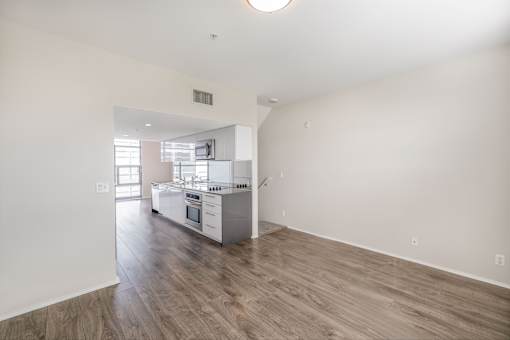 A kitchen with white walls and wooden floors.