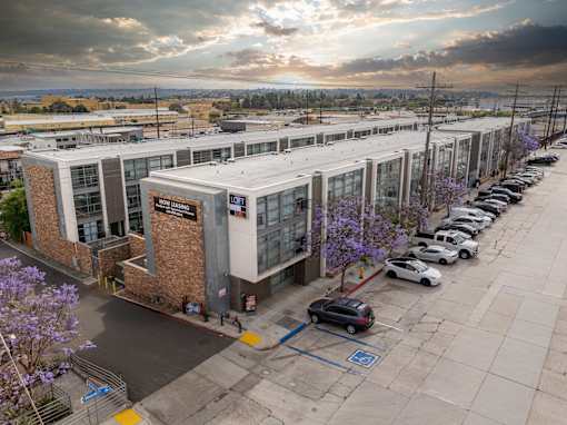 A parking lot with cars and a building with a sign that says "CITY HALL".
