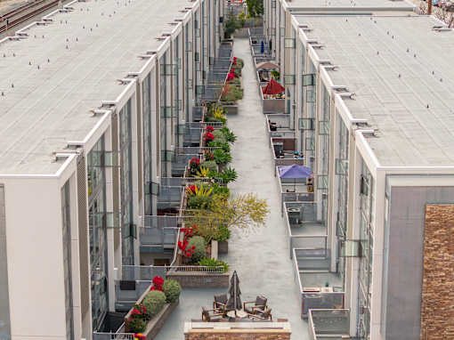 A long building with a lot of windows and plants in front.