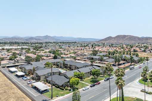 A suburban neighborhood with houses and palm trees.