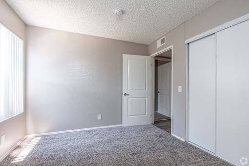 A room with a white door and carpeted floor.