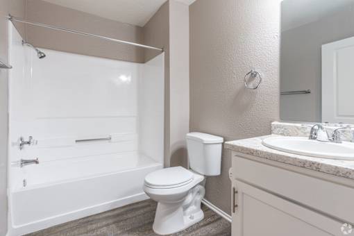 A white toilet sits next to a white sink in a bathroom.