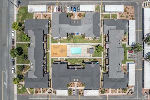 A bird's eye view of a residential area with houses and a swimming pool.