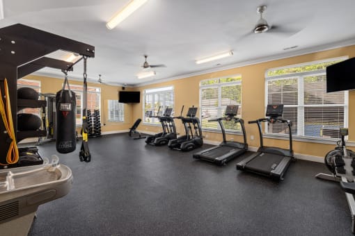 an exercise room with treadmills and other fitness equipment