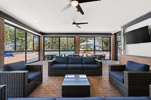 A patio with a blue couch and a ceiling fan.