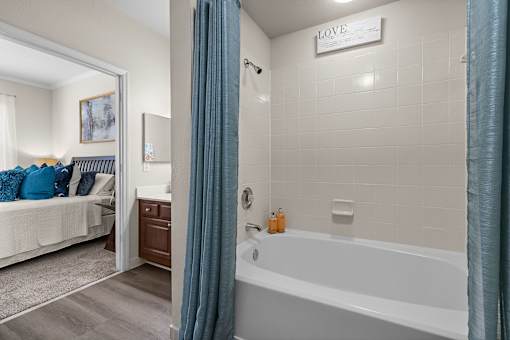 A bathroom with a tub, a bed, and a sign that says "LOVE".