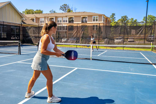 a woman holding a tennis racquet on a tennis court