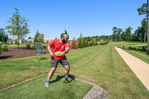 a man holding a frisbee on a grass field
