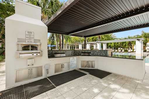 A white outdoor kitchen area with a grill and sink.