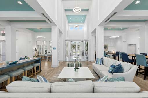 A modern living room with a white sofa and a glass door.
