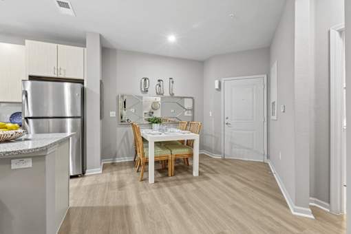 A kitchen with a dining table and chairs.