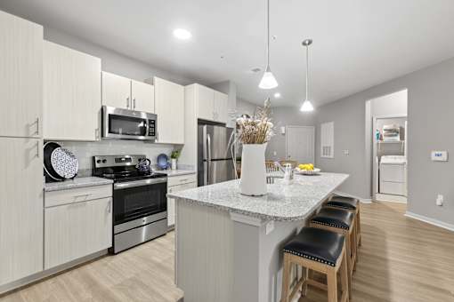 A kitchen with a white countertop and stainless steel appliances.
