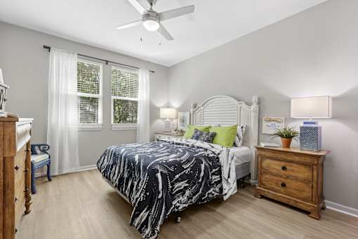 A bedroom with a bed, nightstand, and window.