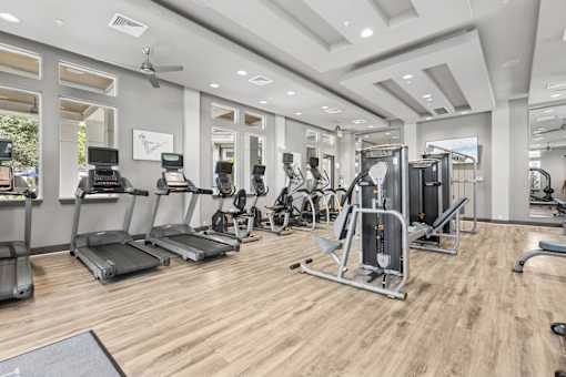 A spacious gym with treadmills, elliptical machines, and other exercise equipment.