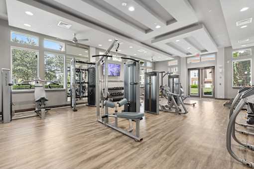 A spacious gym with a variety of equipment and a flat screen TV.