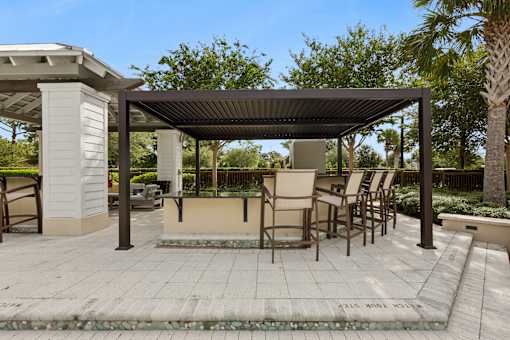 A patio area with a table and chairs under a roof.