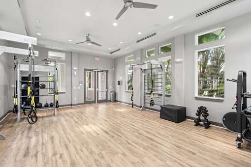 A spacious gym with wooden floors and various exercise equipment.