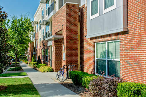 A red brick building with a bicycle parked on the sidewalk.