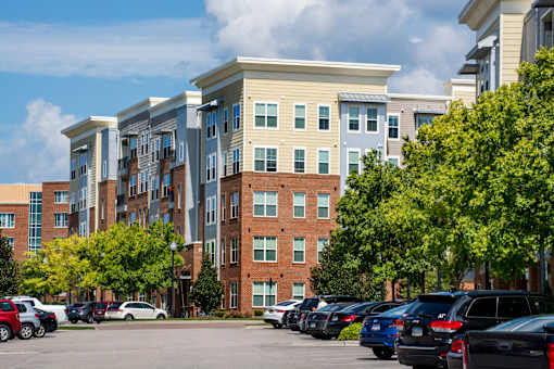A parking lot with cars and apartment buildings in the background.
