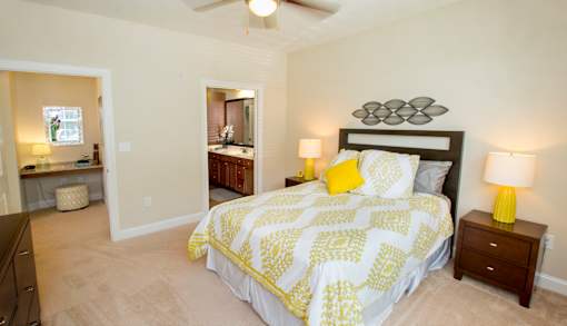 A bedroom with a bed, nightstand, and a ceiling fan.