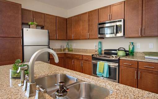 A kitchen with brown cabinets and a granite countertop.