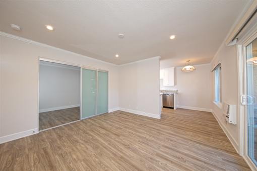 A room with wooden flooring and a window on the right side.