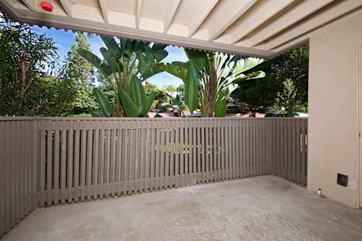 A patio with a wooden fence and a red light on the ceiling.