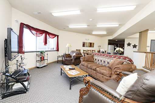 A living room with a brown leather couch and a television.