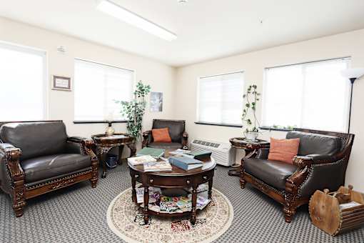 A living room with leather couches and a rug.