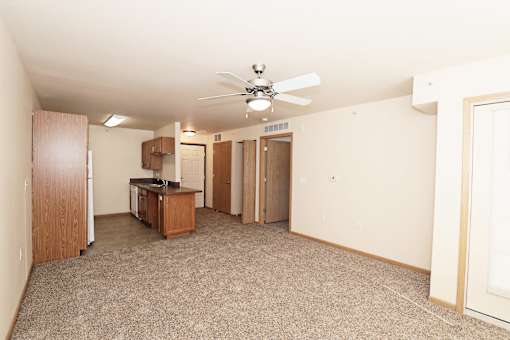 A room with a ceiling fan and carpeted floor.