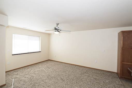 A room with a ceiling fan and a window.