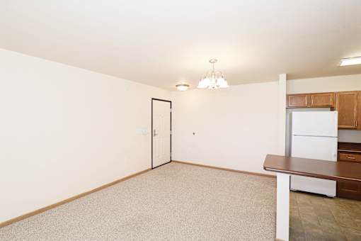A white framed door is in a white room with a brown table and a white framed window.