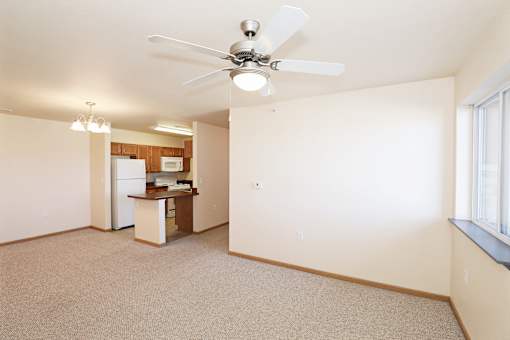 A room with a ceiling fan and a desk with a computer.