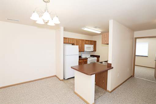 A kitchen area with a refrigerator, microwave, and a counter.