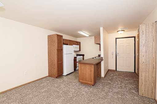 A kitchen area with a refrigerator, microwave, and a countertop.
