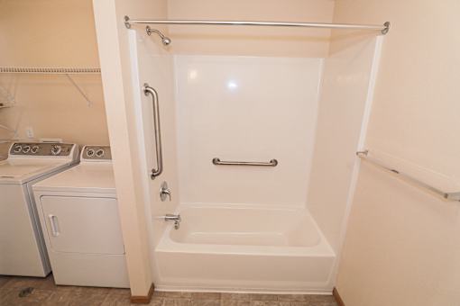A white bathroom with a tub, shower, and toilet.