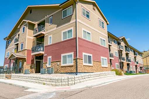 A multi-story apartment building with balconies and a brick facade.
