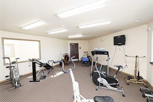 A room with exercise equipment and a television.