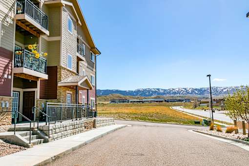 Apartment building with a balcony and a view of the mountains.