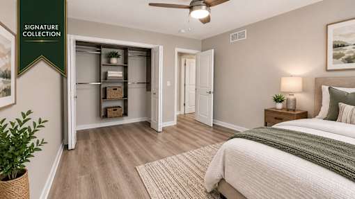 A bedroom with a bed, a ceiling fan, and a cabinet with glass doors.