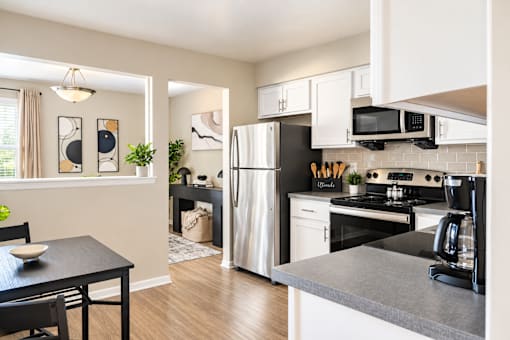 A black and white kitchen with a dining table and chairs.