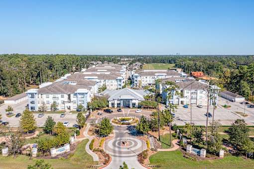 A large white building complex with a circular driveway in front.