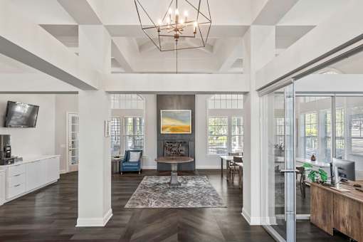 A large, open living room with a high ceiling and a chandelier.