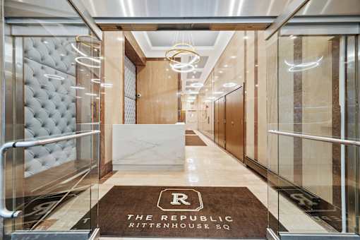A hallway with a brown carpet that says "The Republic Rittenhouse Sq."