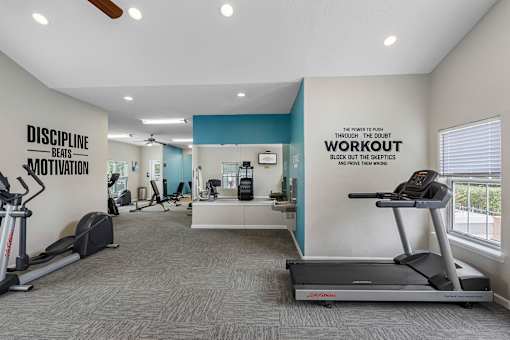 Fitness center with cardio machines - The Colony at Deerwood Apartments