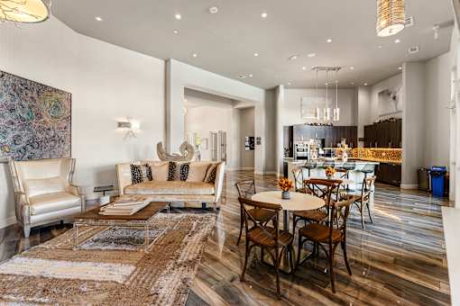 A modern living room with a large rug and a dining table set up.