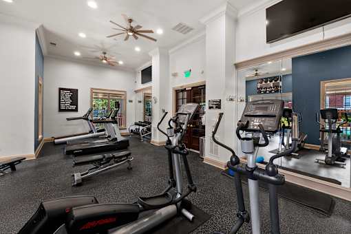 Fitness center with weight and cardio machines - Belle Harbour Apartments
