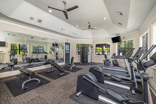 A gym with treadmills, elliptical machines, and other exercise equipment.